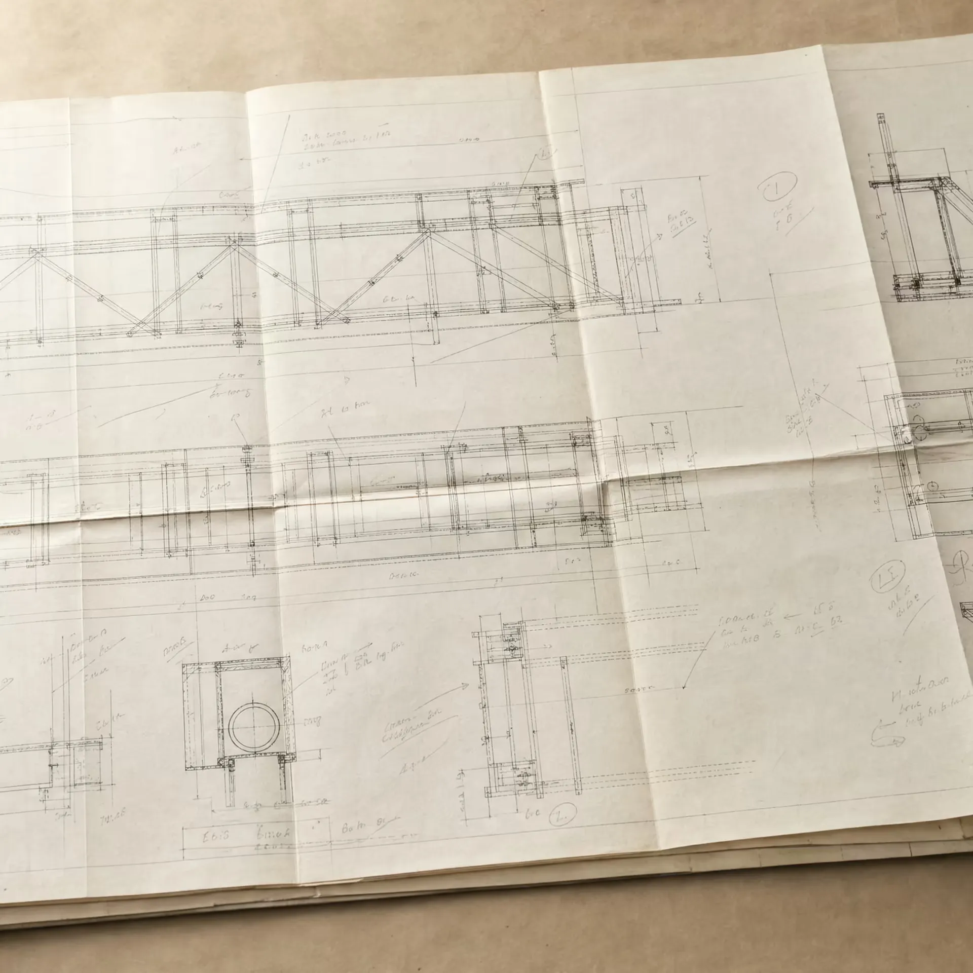 A folded architectural blueprint and a draughtsman's set square resting on a drawing board, lit from one side in black and white, fine grid lines receding across the sheet.