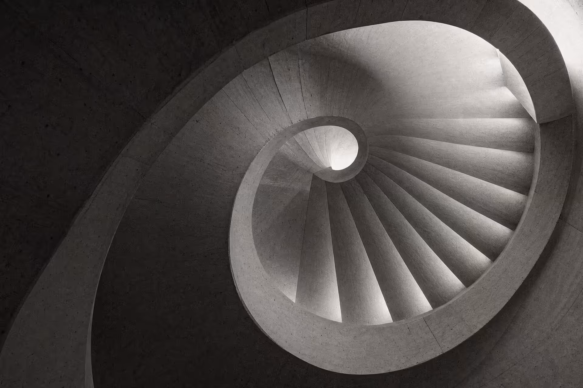 Cast-concrete spiral stair lit from a central oculus, warm-tone monochrome.