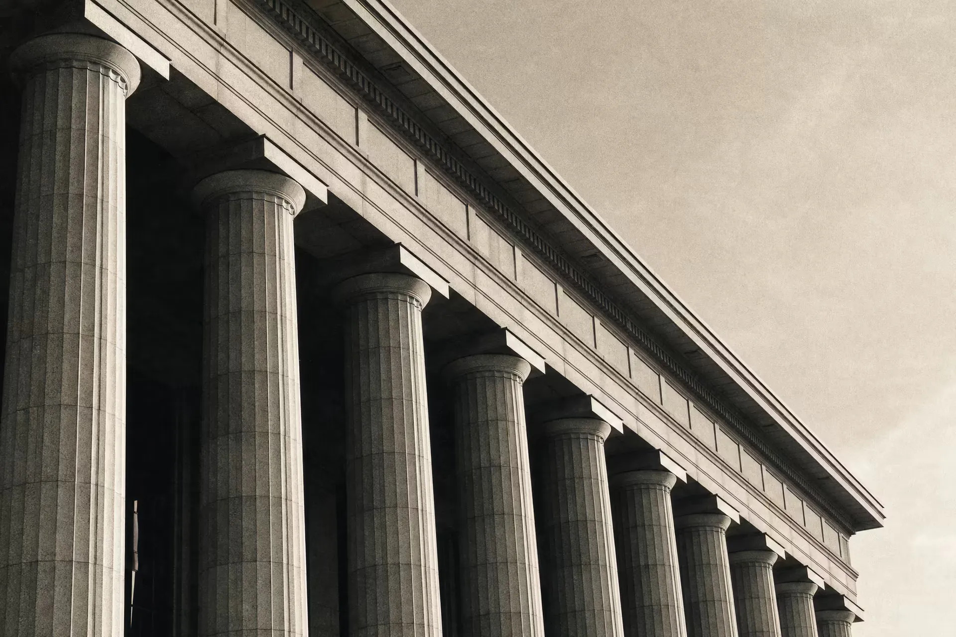 A neoclassical stock-exchange facade with tall fluted columns, warm-tone monochrome.