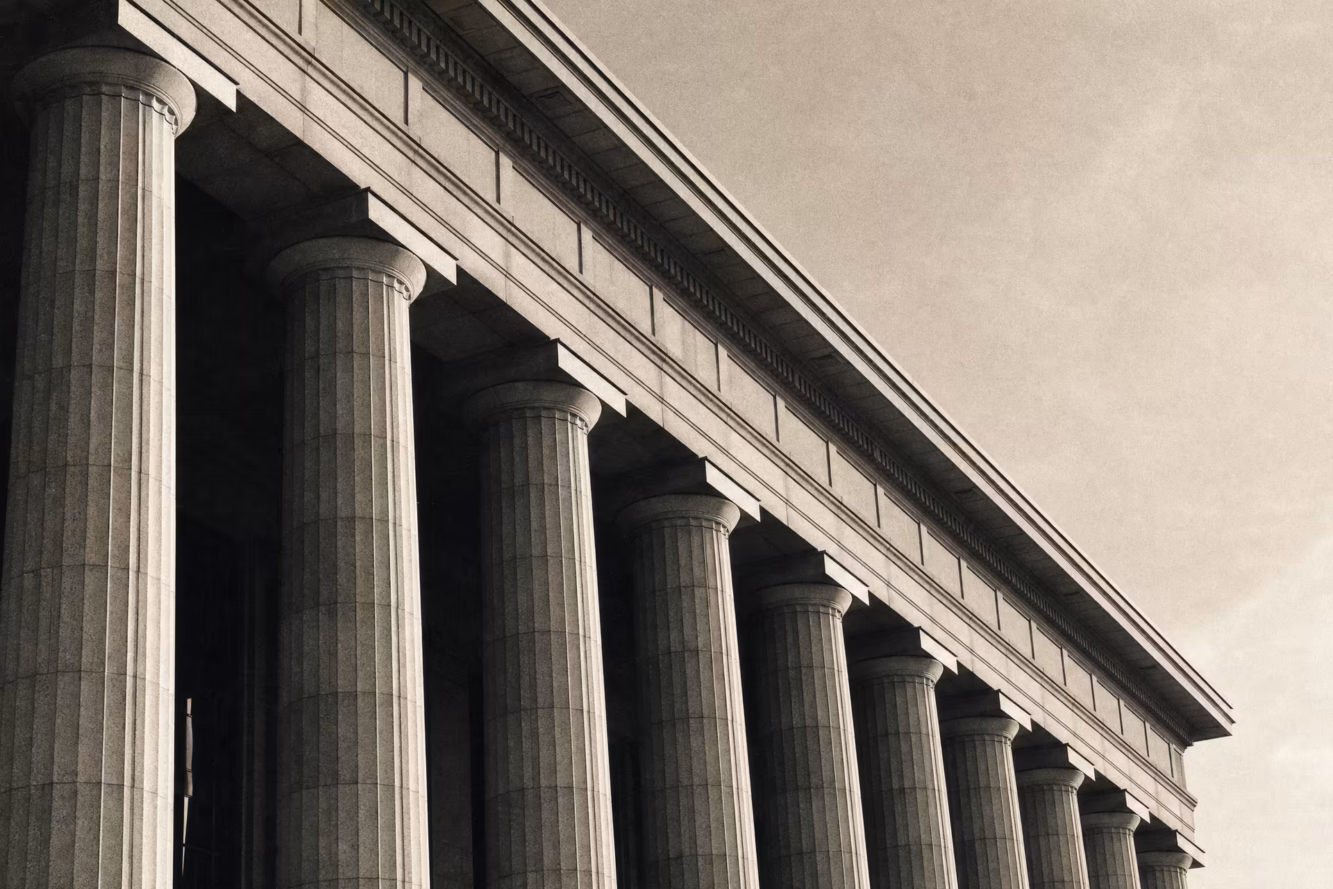 A neoclassical stock-exchange facade with tall fluted columns, warm-tone monochrome.